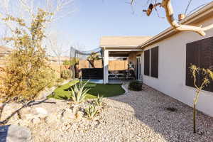 Fully fenced backyard with a covered patio and a hot tub.