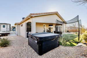 Rear view of property with a hot tub, covered patio, and RV pa, and RV dump.