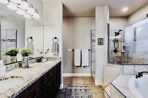 Primary suite bath with soaker tub, walk in shower, and granite counter double vanity.