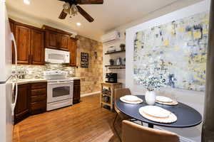 Apt. #1 Kitchen with cement countertops, white appliances, alder wood cabinets, and tiled  backsplash