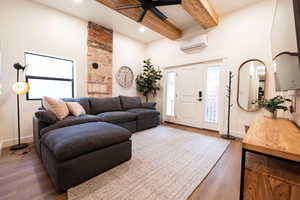 Apt. #4 Family Room featuring high ceiling wood beams and original rock accent wall