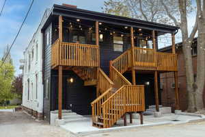 View of building back exterior featuring patio, decks and stairway