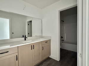 Full bath with vanity, bathing tub / shower combination, and dark wood finished floors