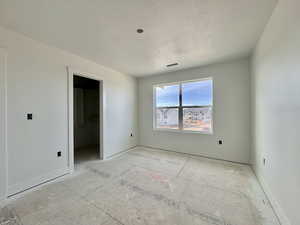 Empty room with baseboards and a textured ceiling