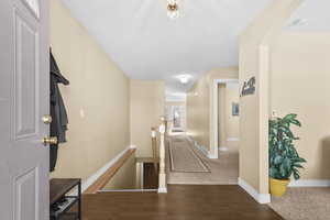 Corridor featuring an upstairs landing, wood finished floors, and carpet floors