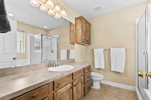 Bathroom with a shower stall, vanity, and light tile patterned floors