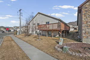View of property exterior with a wooden deck, stucco siding, and a residential view