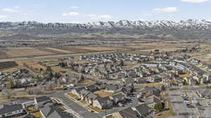 Aerial view of property and surrounding area featuring nearby suburban area and a mountain backdrop