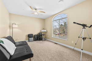 Living area with carpet flooring and ceiling fan