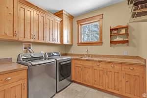Laundry area featuring cabinet space and washer and clothes dryer
