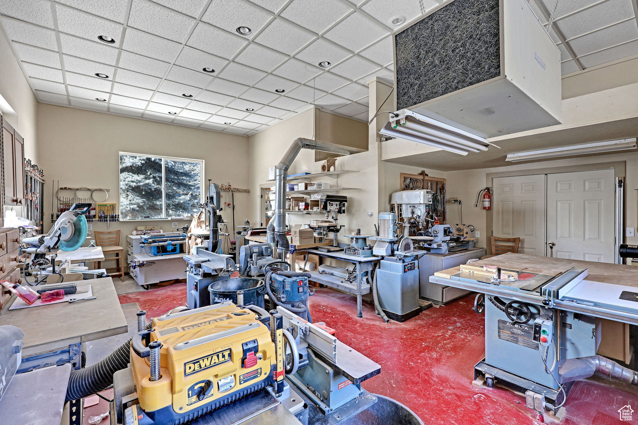 Interior space featuring a heating unit, a workshop area, and a paneled ceiling