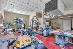 Interior space featuring a heating unit, a workshop area, and a paneled ceiling