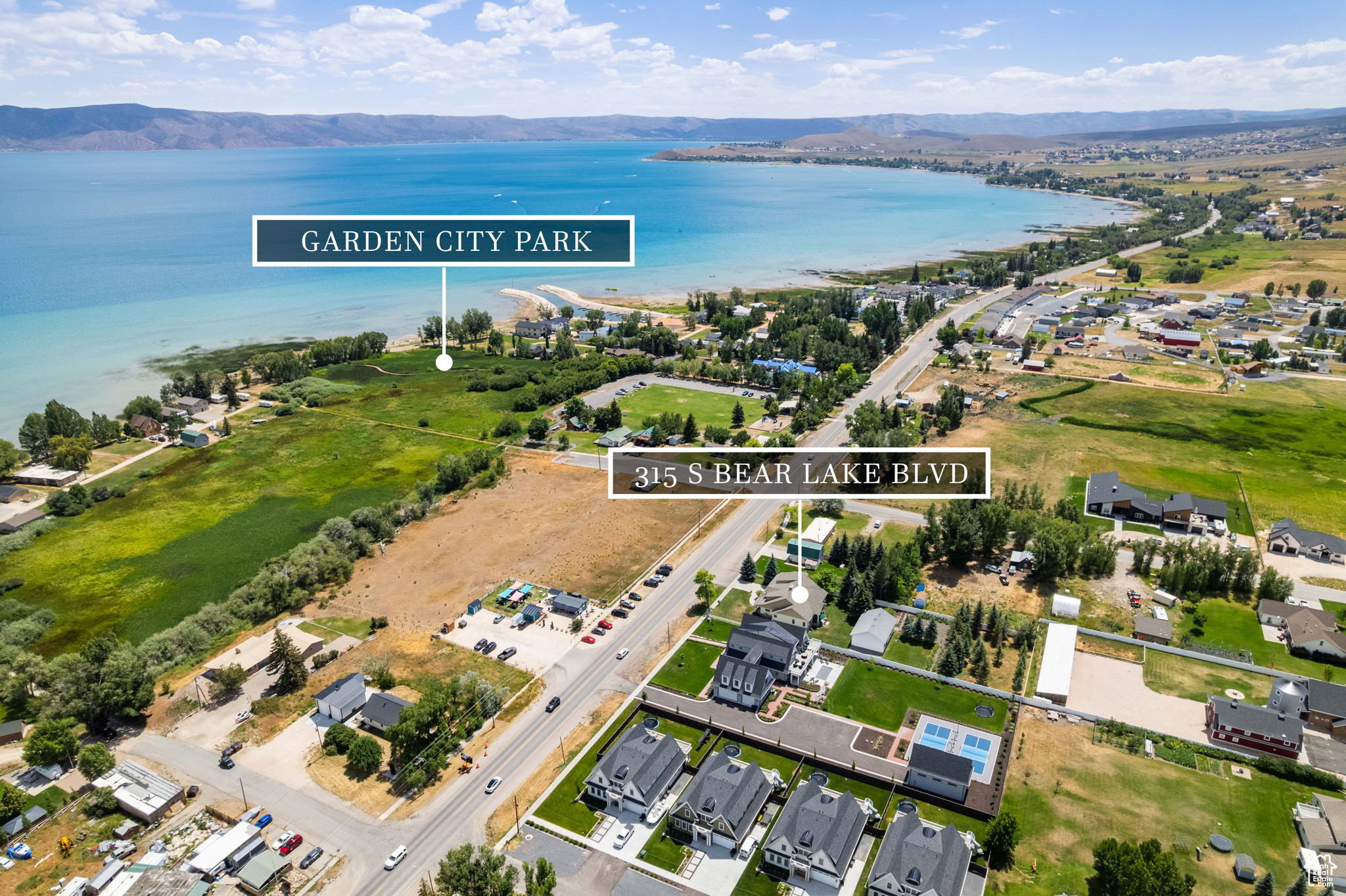 Aerial view of property's location with nearby suburban area, a water and mountain view, and property boundaries highlighted