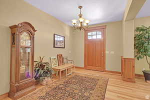 Foyer entrance featuring a chandelier and light wood-style floors