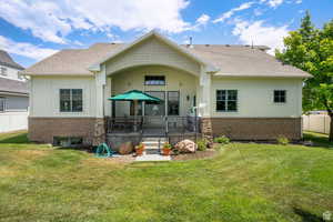 Back of house featuring board and batten siding, roof with shingles, brick siding, and a patio
