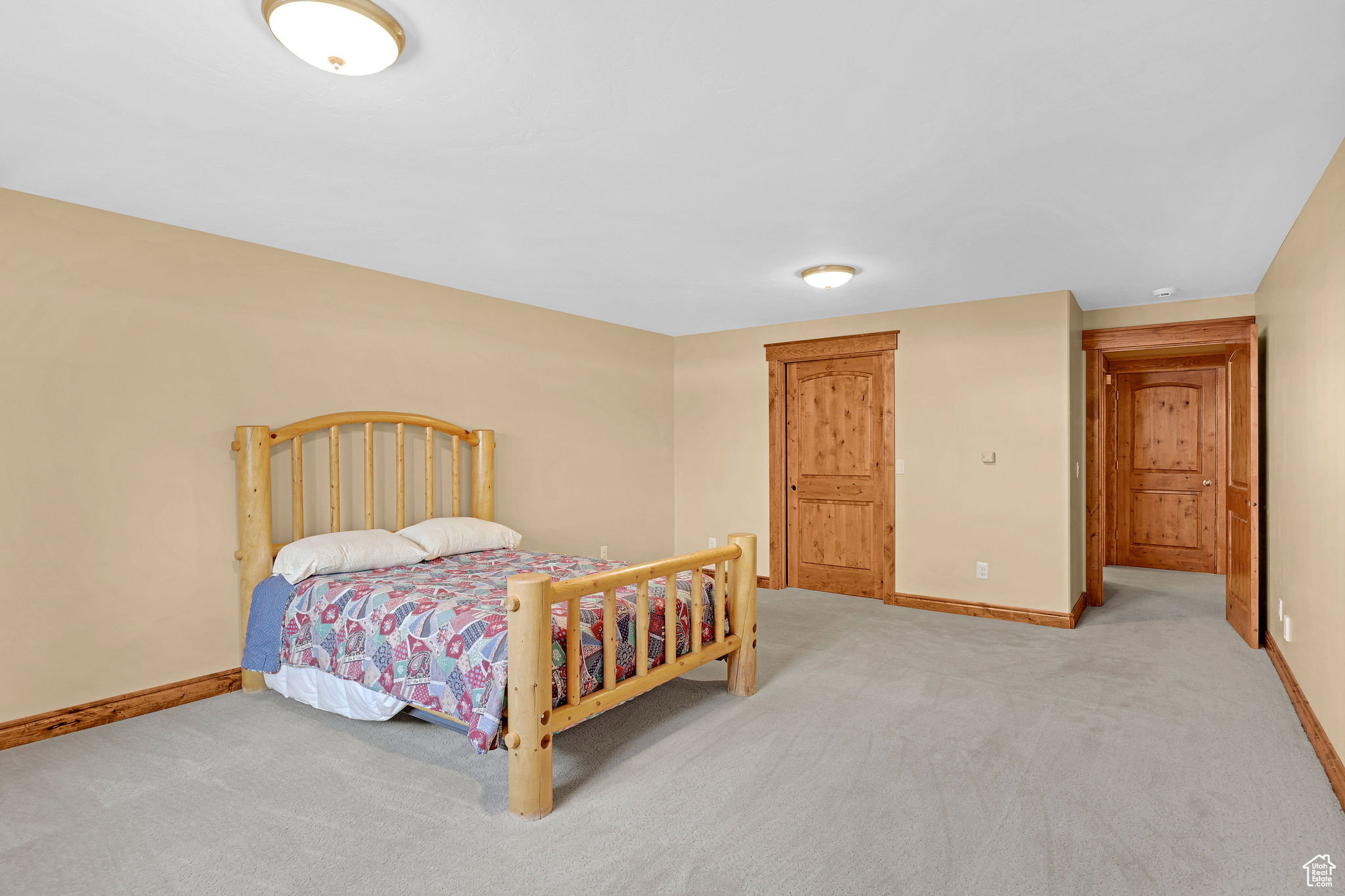 Bedroom featuring baseboards and light carpet