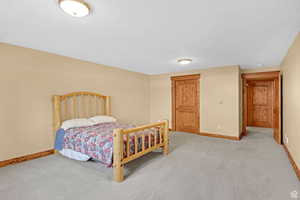 Bedroom featuring baseboards and light carpet