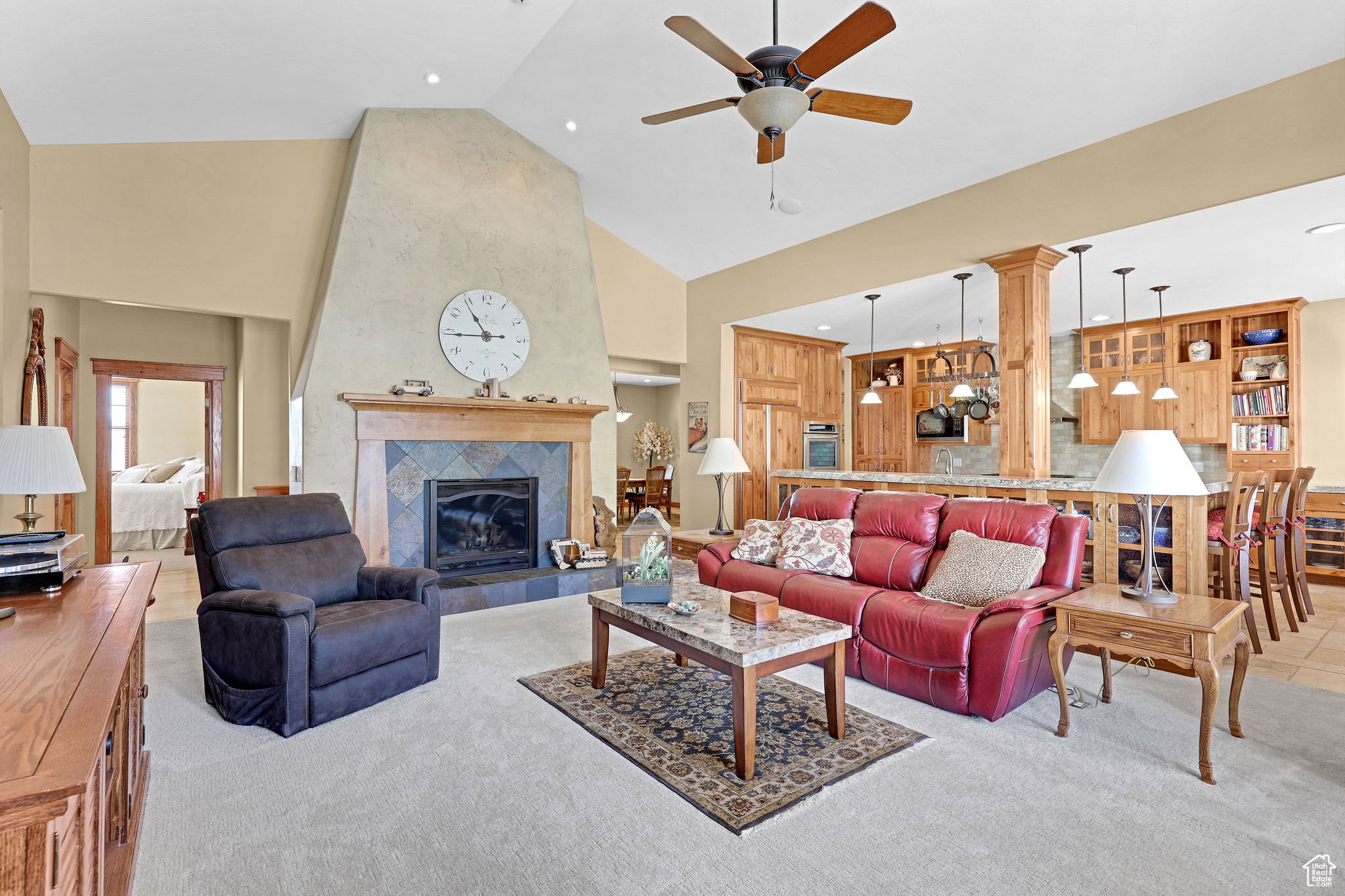 Living area with high vaulted ceiling, carpet, a ceiling fan, a tile fireplace, and recessed lighting