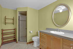 Full bathroom with a stall shower, vanity, and light tile patterned floors