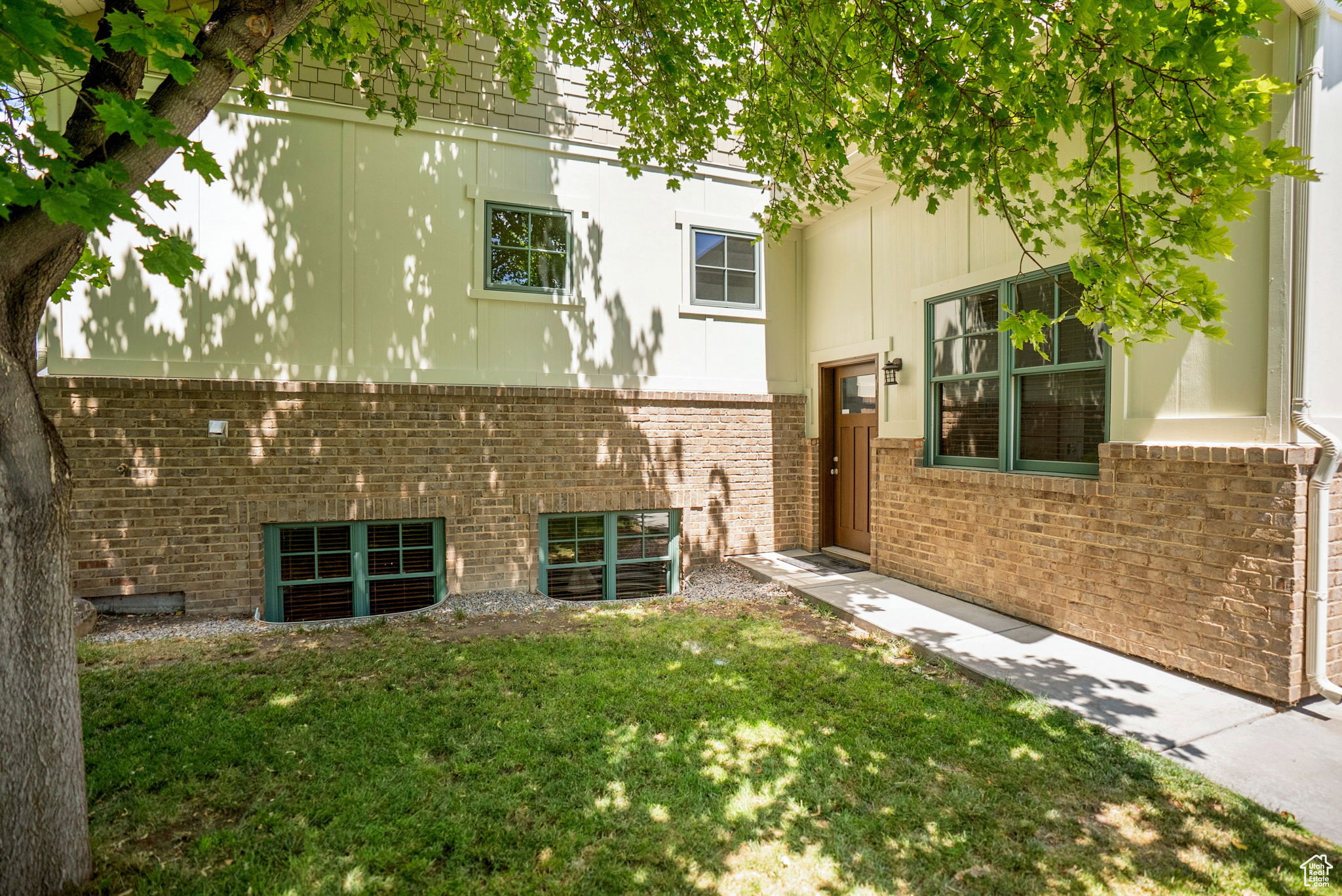 View of side of home with a yard and brick siding