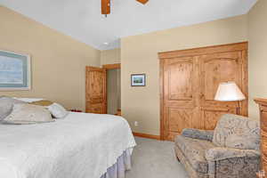 Carpeted bedroom featuring a ceiling fan and a closet