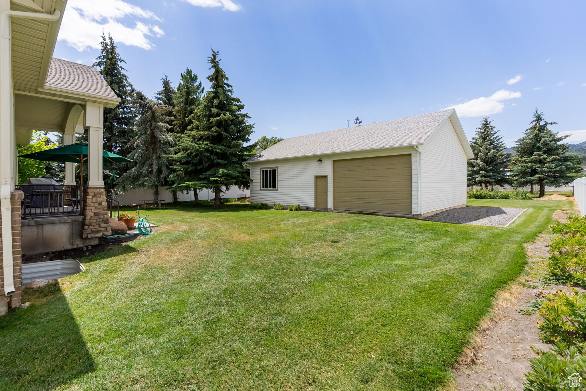 View of grassy yard with an outbuilding and a garage