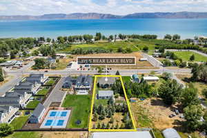 Aerial perspective of suburban area with property parcel outlined and a water and mountain view