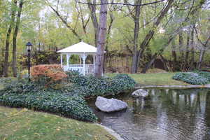 View of grassy yard with a gazebo and a water view