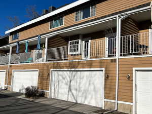 View of property exterior featuring a balcony and an attached garage