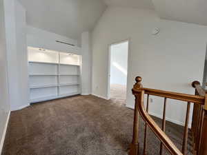 upstairs landing often used as an office space or study with bookcase and a high ceiling