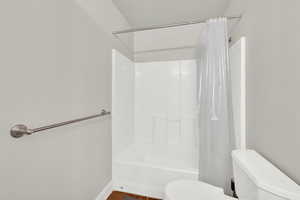 Bathroom with toilet and shower / bath combo with shower curtain