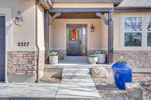 Property entrance featuring stone siding and stucco siding