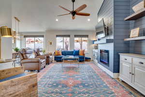 Living room featuring a ceiling fan, healthy amount of natural light, a large fireplace, light wood-type flooring, and recessed lighting
