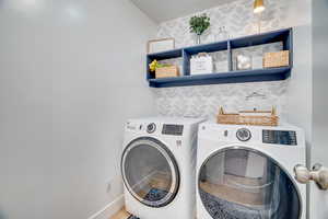 Laundry area with washer and dryer and baseboards