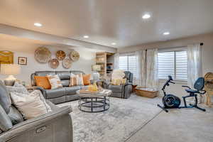 Living area featuring carpet flooring, recessed lighting, and a textured ceiling