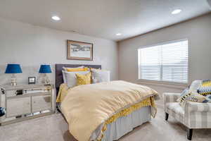 Bedroom featuring light colored carpet, recessed lighting, and a textured ceiling