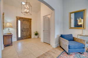 Entryway with hanging lights, wood finished floors, and lofted ceiling