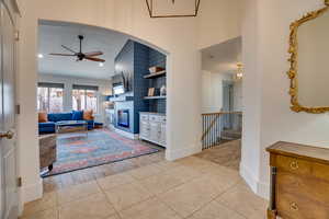 Living area featuring light tile patterned floors, a ceiling fan, a fireplace, recessed lighting, and lofted ceiling