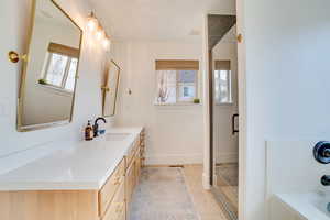 Full bath featuring vanity, a garden tub, a stall shower, and light tile patterned floors