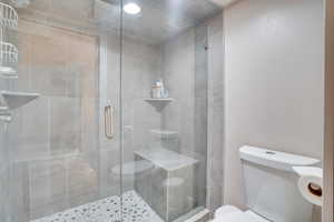 Bathroom featuring toilet and a stall shower