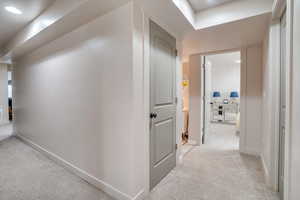 Corridor featuring light colored carpet and recessed lighting