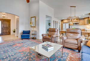 Living area with hanging lights, arched walkways, a high ceiling, and washer / clothes dryer