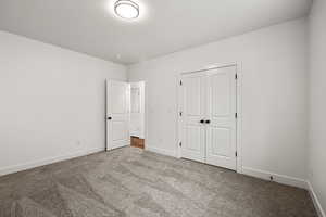 Unfurnished bedroom with a closet and carpet