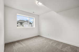 Carpeted empty room with baseboards