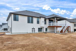 Back of property featuring a patio, roof with shingles, a wooden deck, and stucco siding