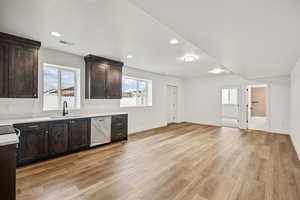 Bar area with dark wood finish cabinets, dishwasher, light wood-type flooring, and recessed lighting