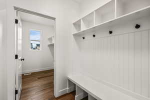 Mudroom featuring dark wood-type flooring and baseboards