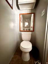 Bathroom featuring toilet and dark tile patterned flooring