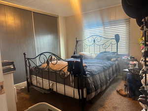 Bedroom featuring carpet floors and wooden walls
