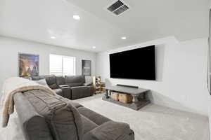 Living area featuring light carpet and recessed lighting